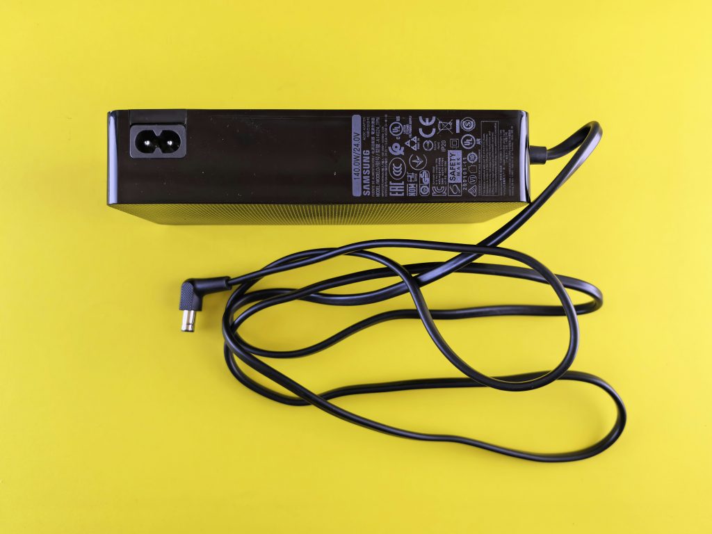 Laptop-Netzteil defekt – Netzteil mit Kabel neben einem Notebook