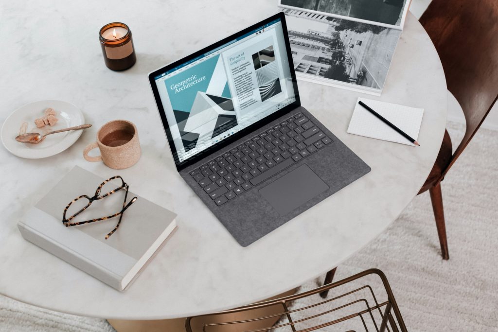 Laptop für Juristen – Notebook mit Gesetzbüchern auf dem Schreibtisch
